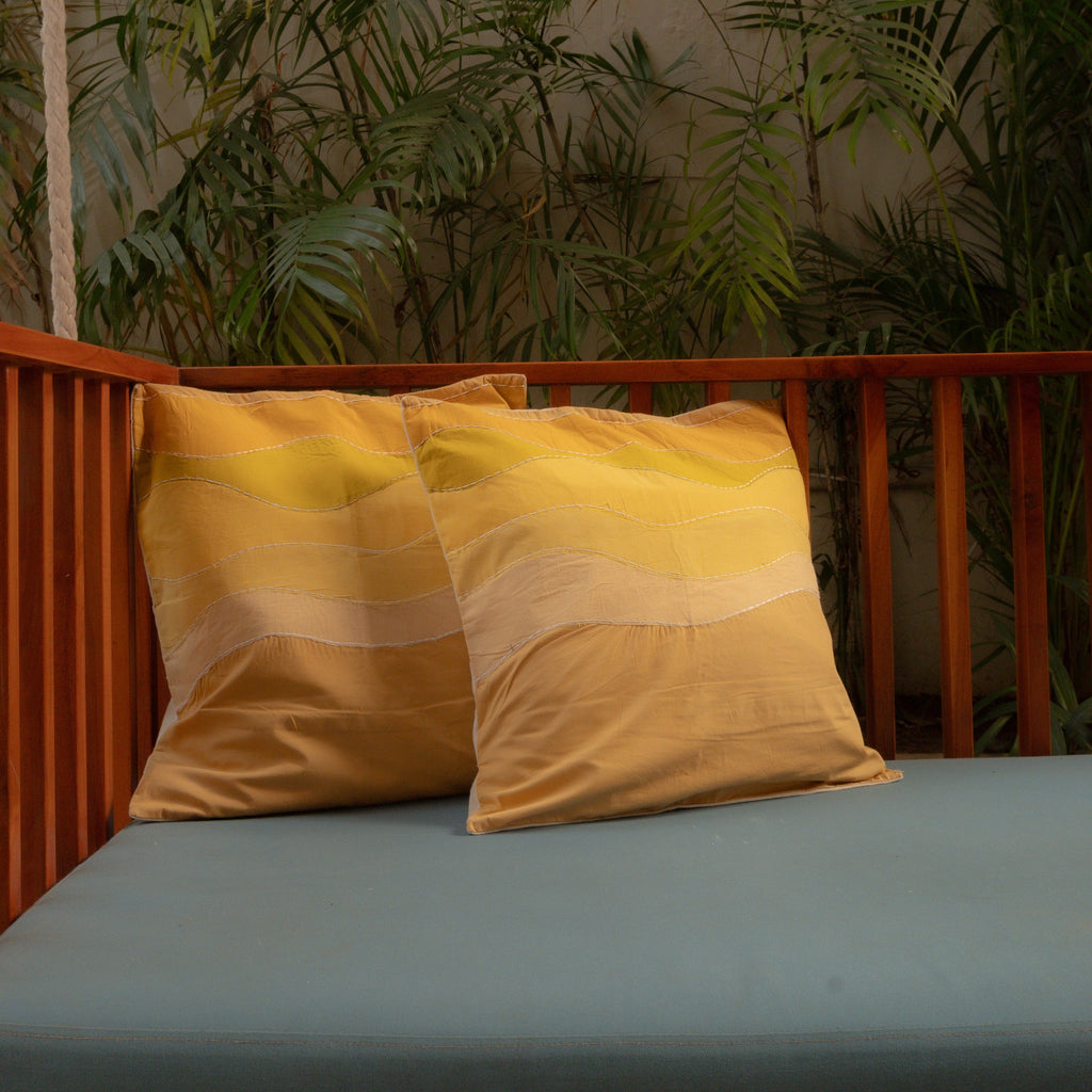 Outdoor seating area with pure cotton yellow pillows and greenery in the background