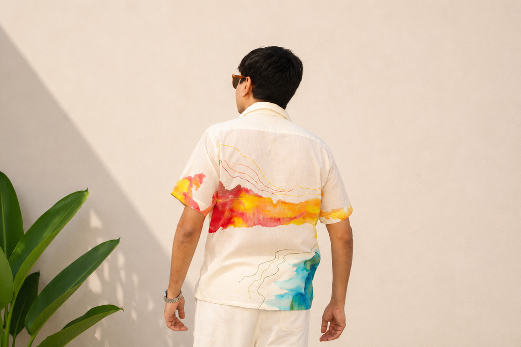 Person wearing a colorful shirt with abstract patterns against a plain background