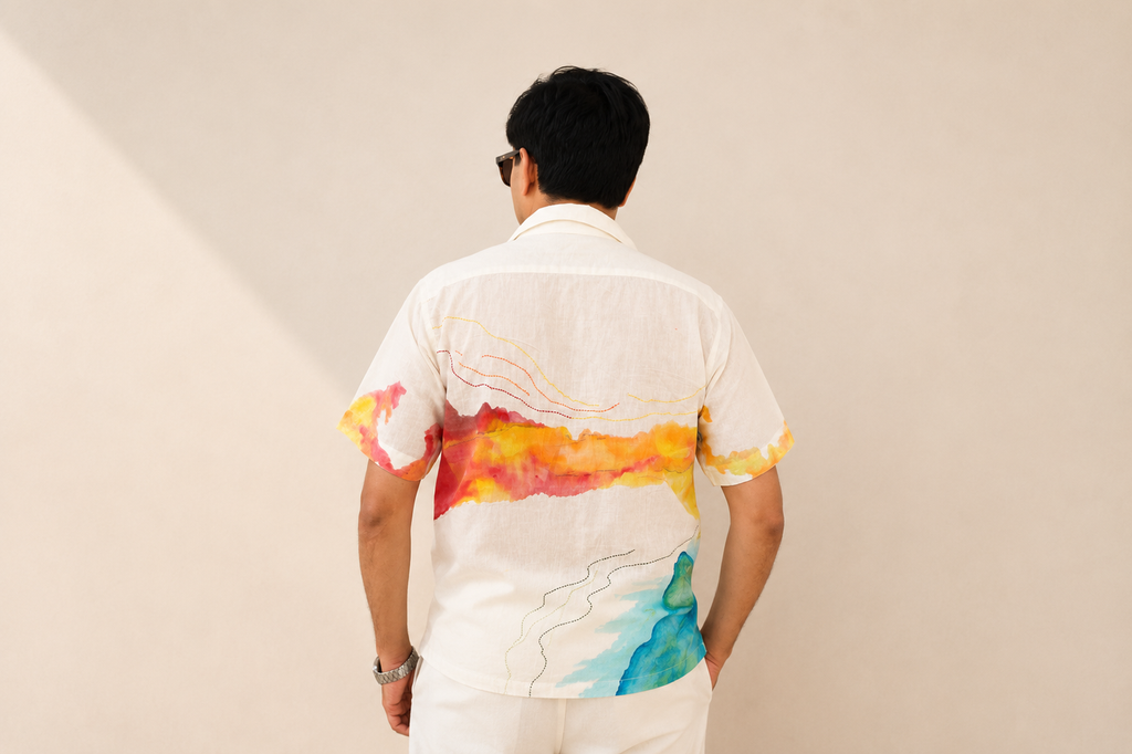 Person wearing a colorful shirt with abstract designs on a plain background