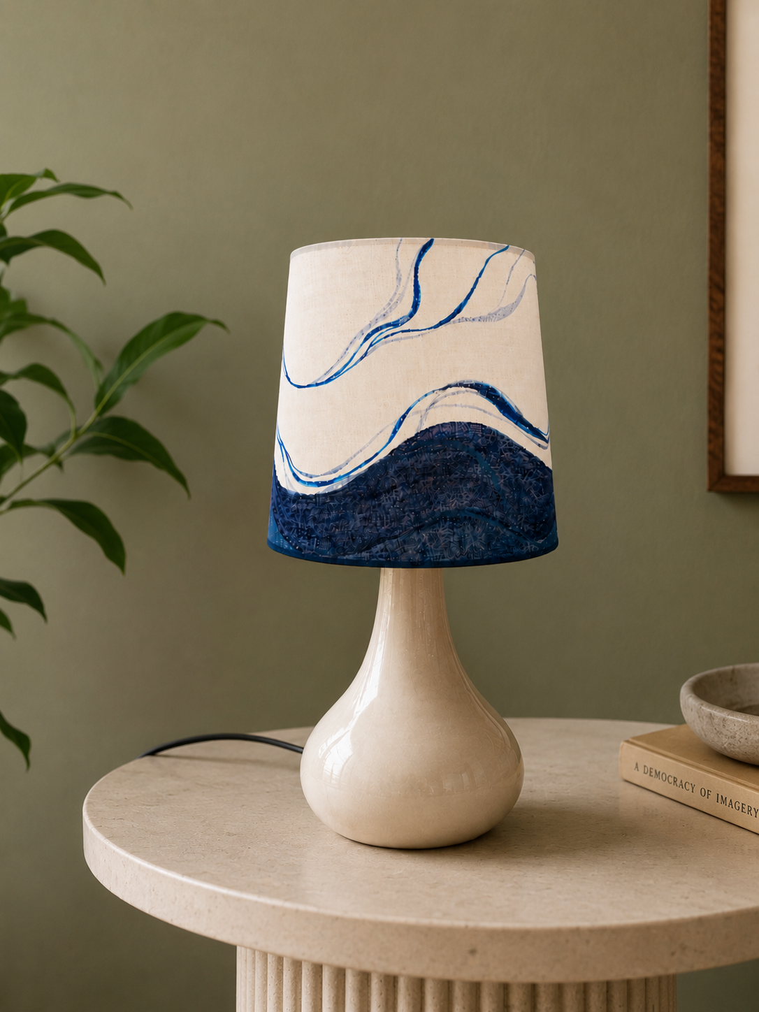 Table lamp with a marbled design on a wooden table against a green wall.