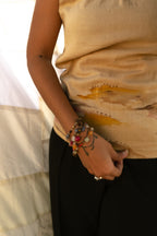 Beige cotton sleeveless top with abstract artwork detail, relaxed summer top for casual outfits and vacation styling.