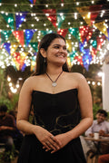 Black corset top featuring artistic gold detailing, strapless party top for evening occasions and festive gatherings.