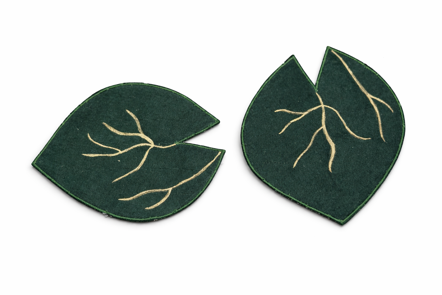 Pair of green leaf-shaped fabric coasters with gold detailing
