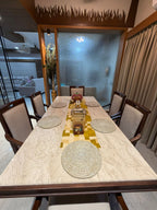 Dining room with a long table set for a meal, chairs, and decorative elements.