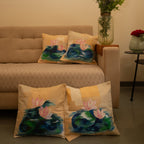 Living room with beige sofa and decorative pillows featuring floral designs, wall art, and a vase with flowers.