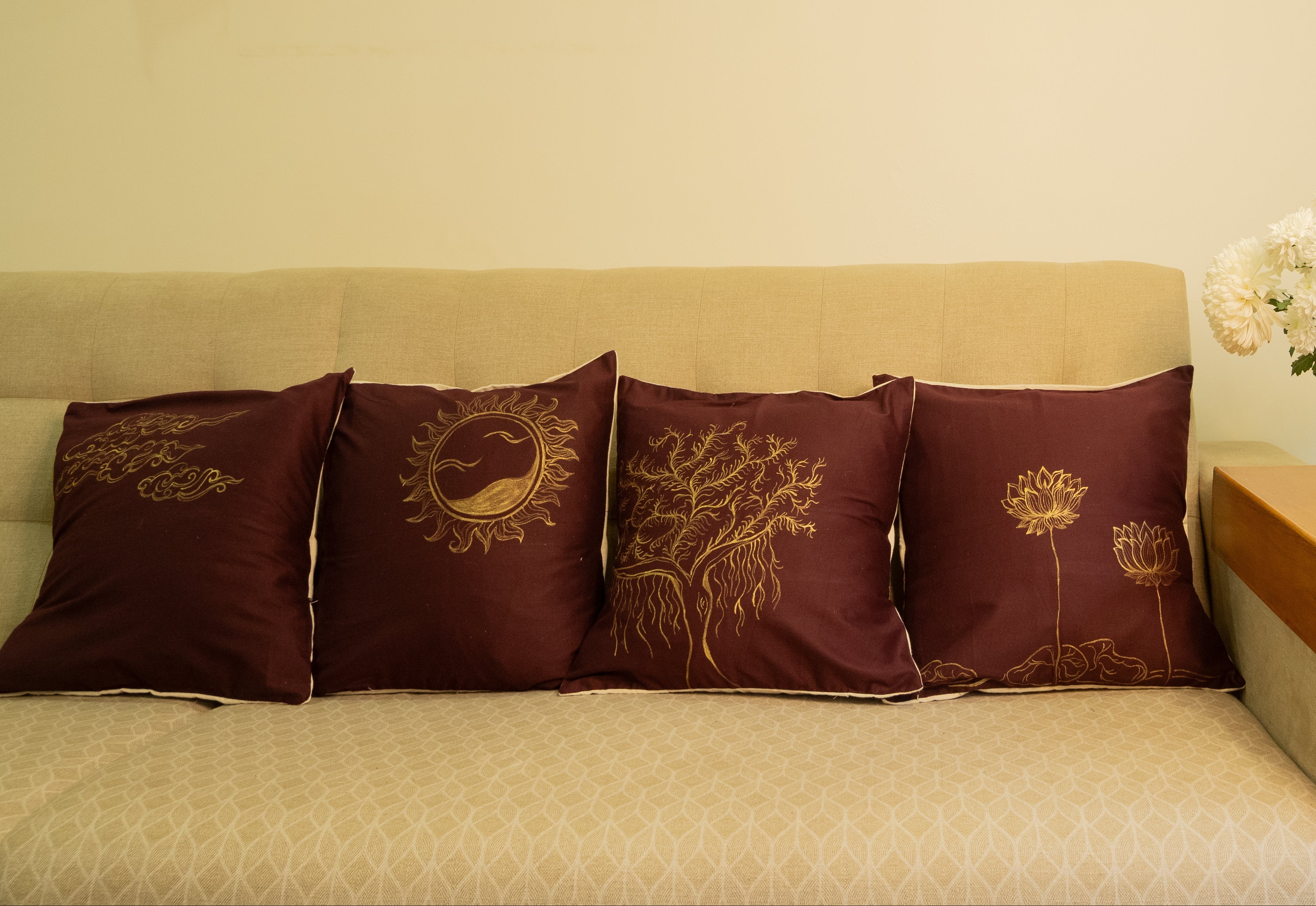 Beige sofa with decorative hand painted pillows and a small table