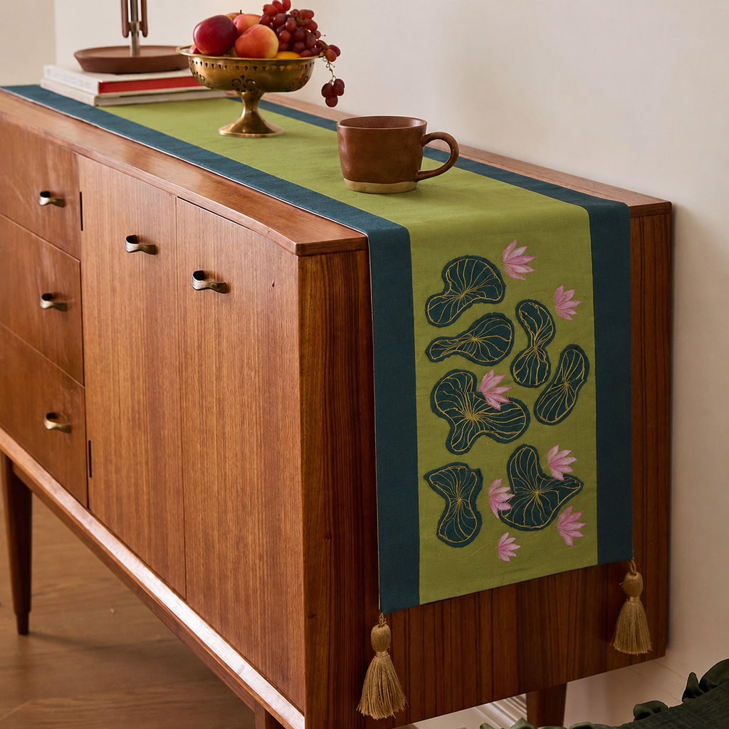 Wooden sideboard with a decorative table runner featuring floral patterns and tassels.