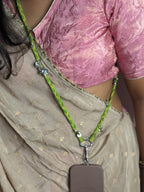 Person wearing a pink blouse and green and silver lanyard with a phone case.