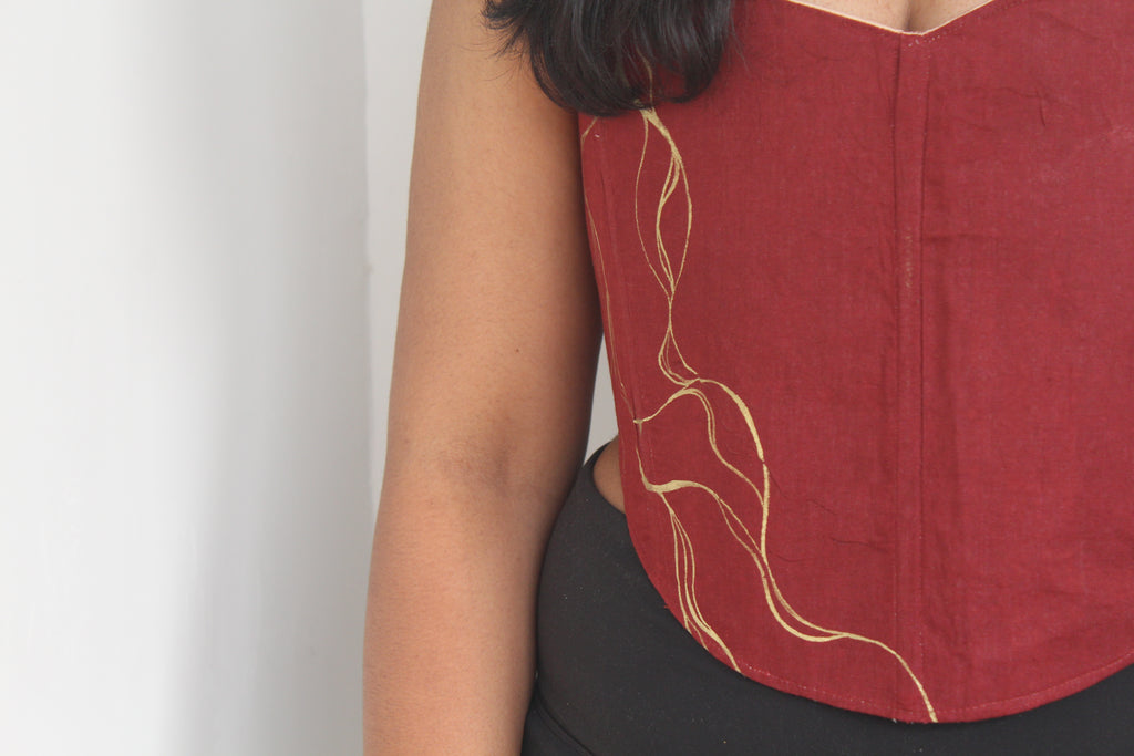 Red top with gold Painting on a plain background