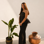 Woman standing next to a plant and a copper pot in a minimalistic setting
