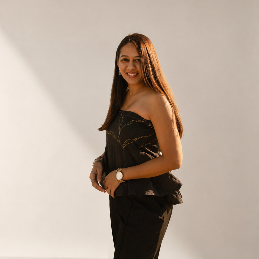 Woman wearing a black strapless top and pants against a plain background