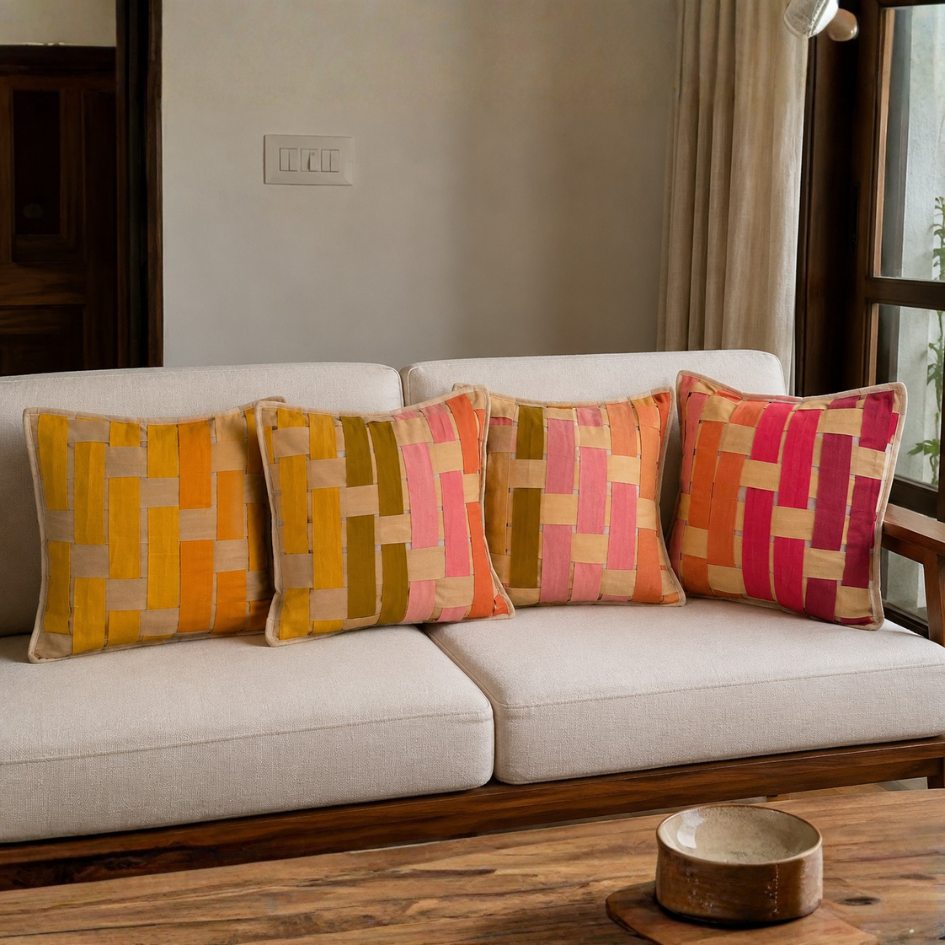 Decorative pillows with geometric patterns on a beige sofa in a living room setting.
