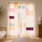 Living room with a white sofa, wooden coffee table, and colorful geometric-patterned curtains.