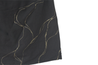 Close-up of a black top with gold thread patterns with golden