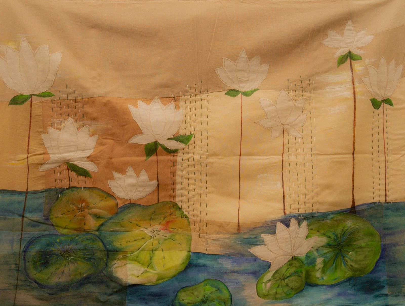 Fabric wall art depicting lotus flowers rising from water with painted details and kantha embroidery, decorative textile artwork for modern interiors.