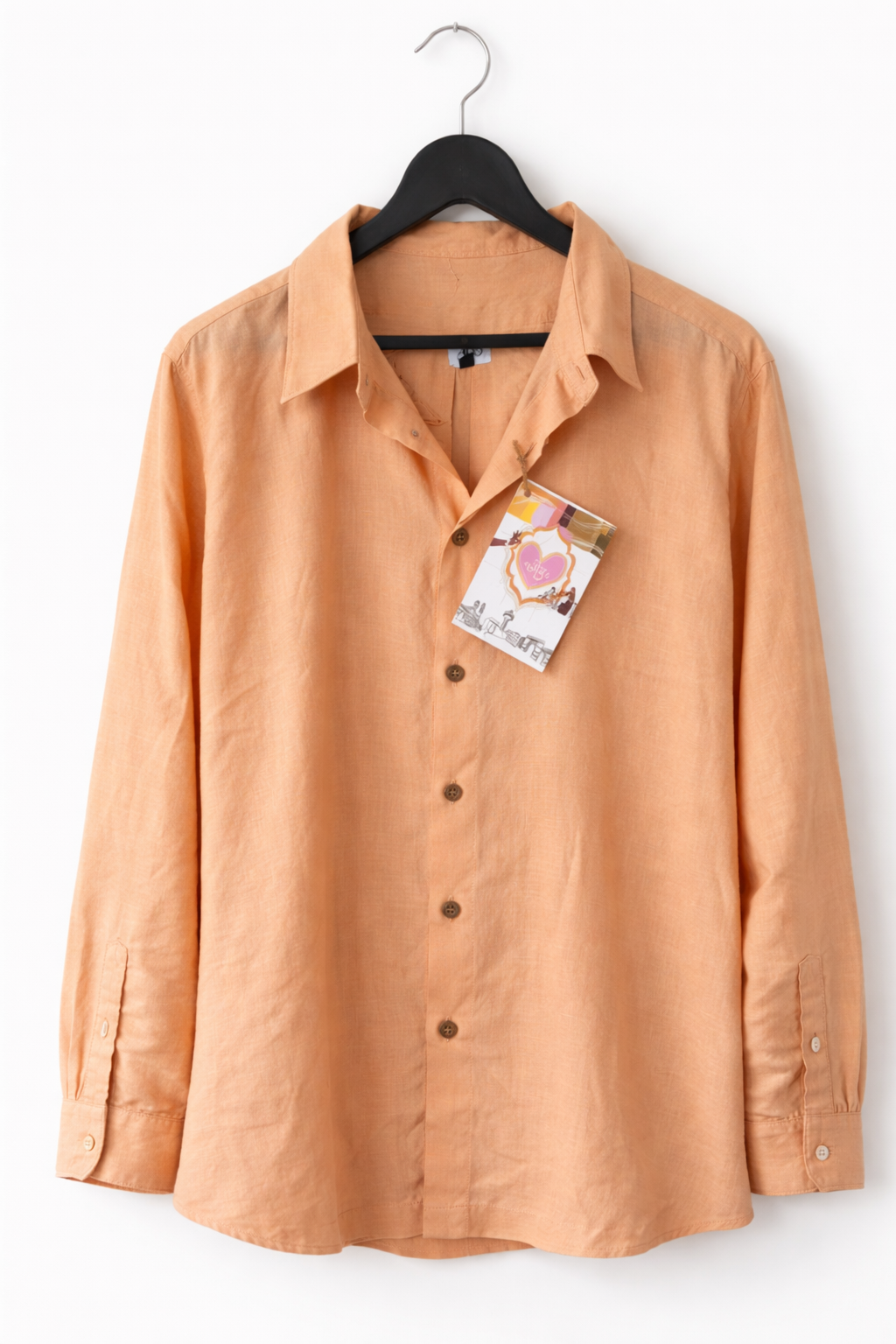 Orange shirt on a hanger with a tag on a white background