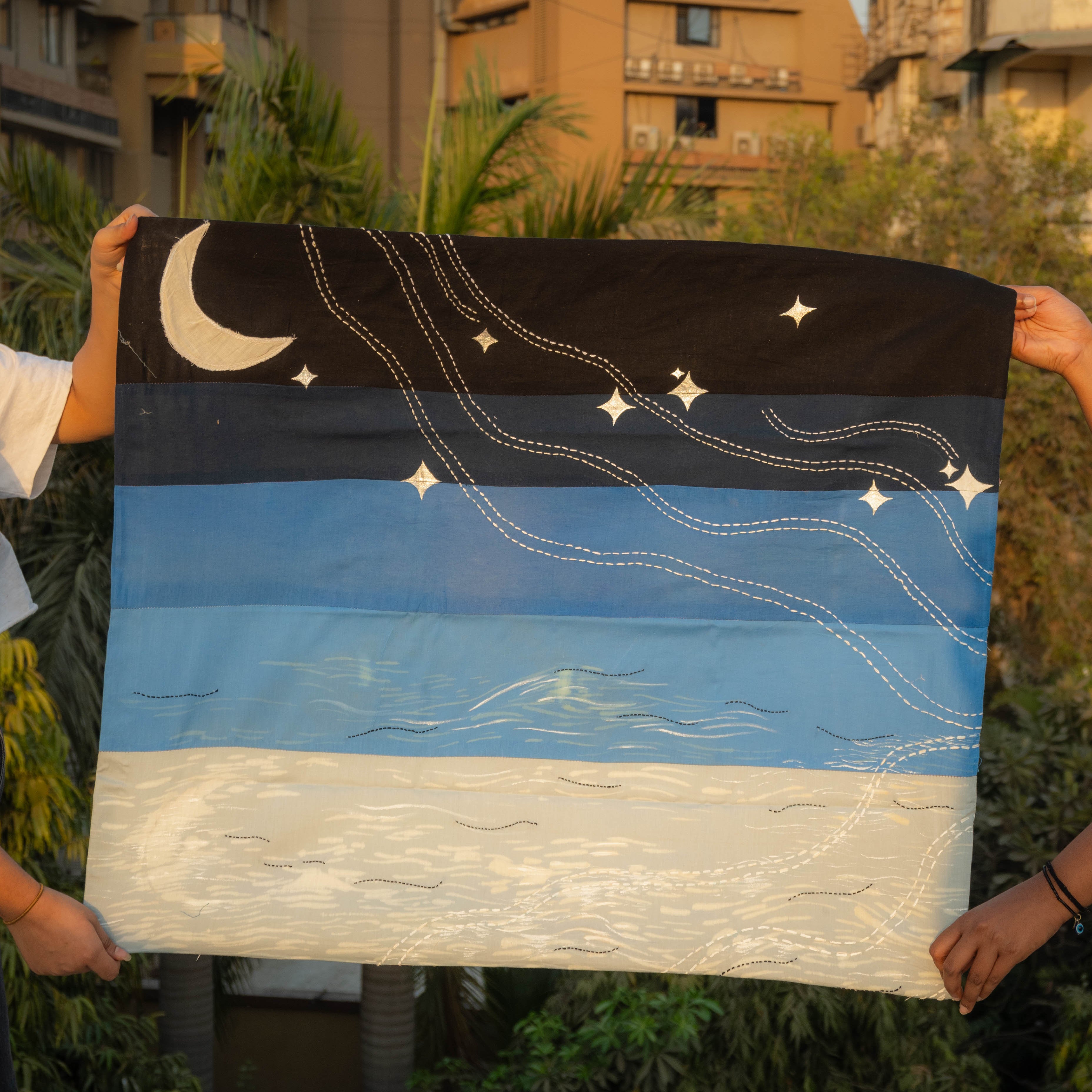 Person holding a starry night sky tapestry