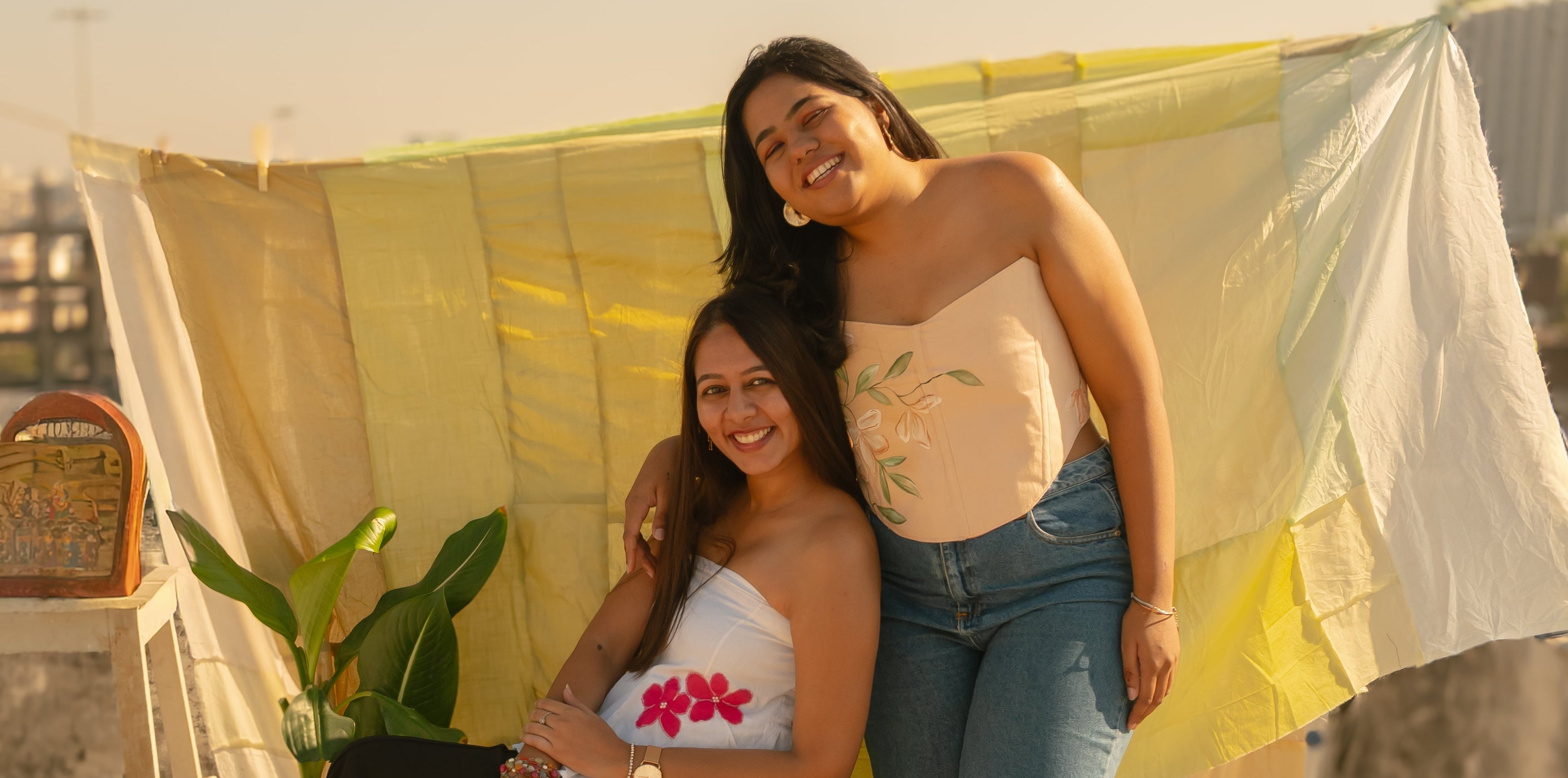 Two women wearing a tube top and corset