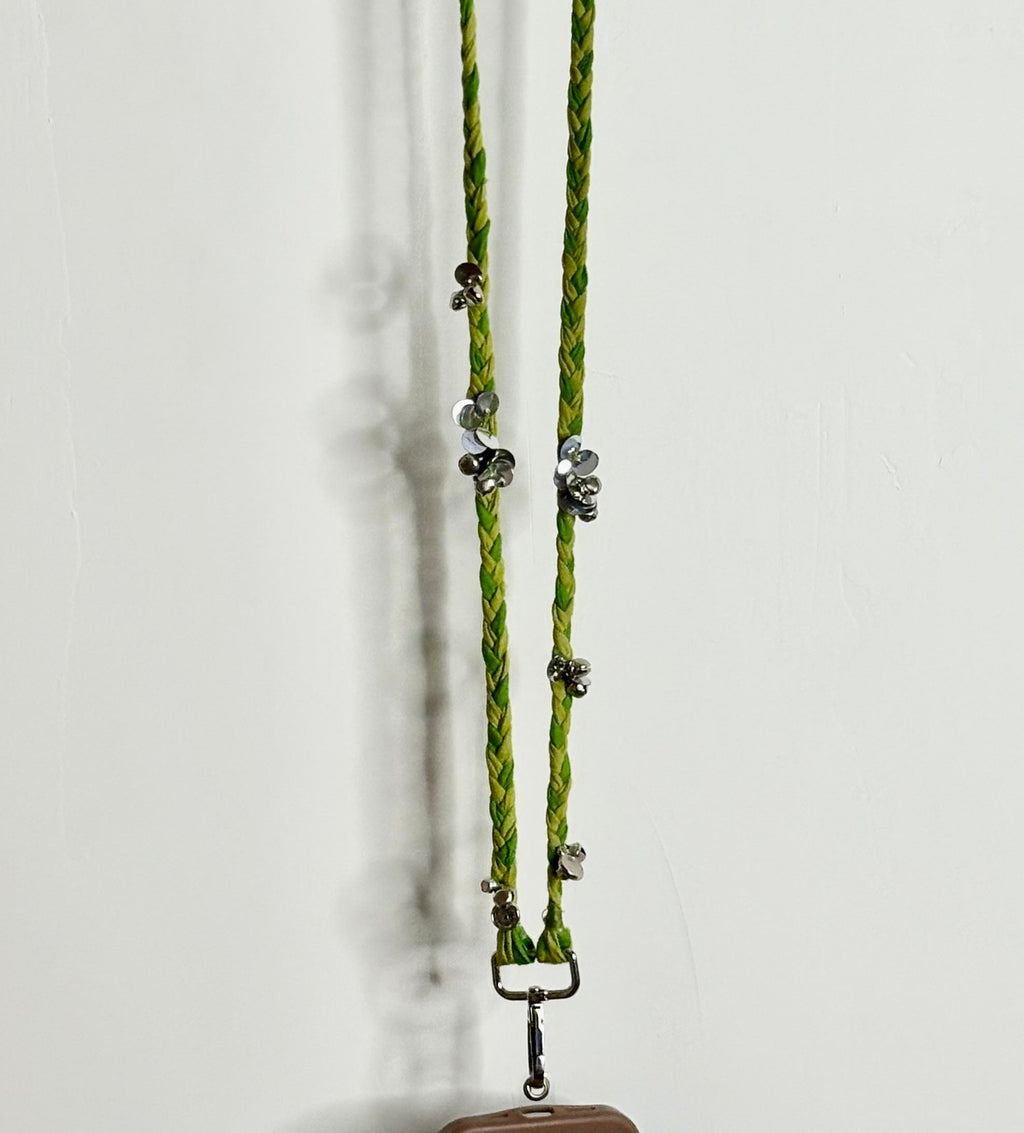 Green braided lanyard with metal clips on a white background