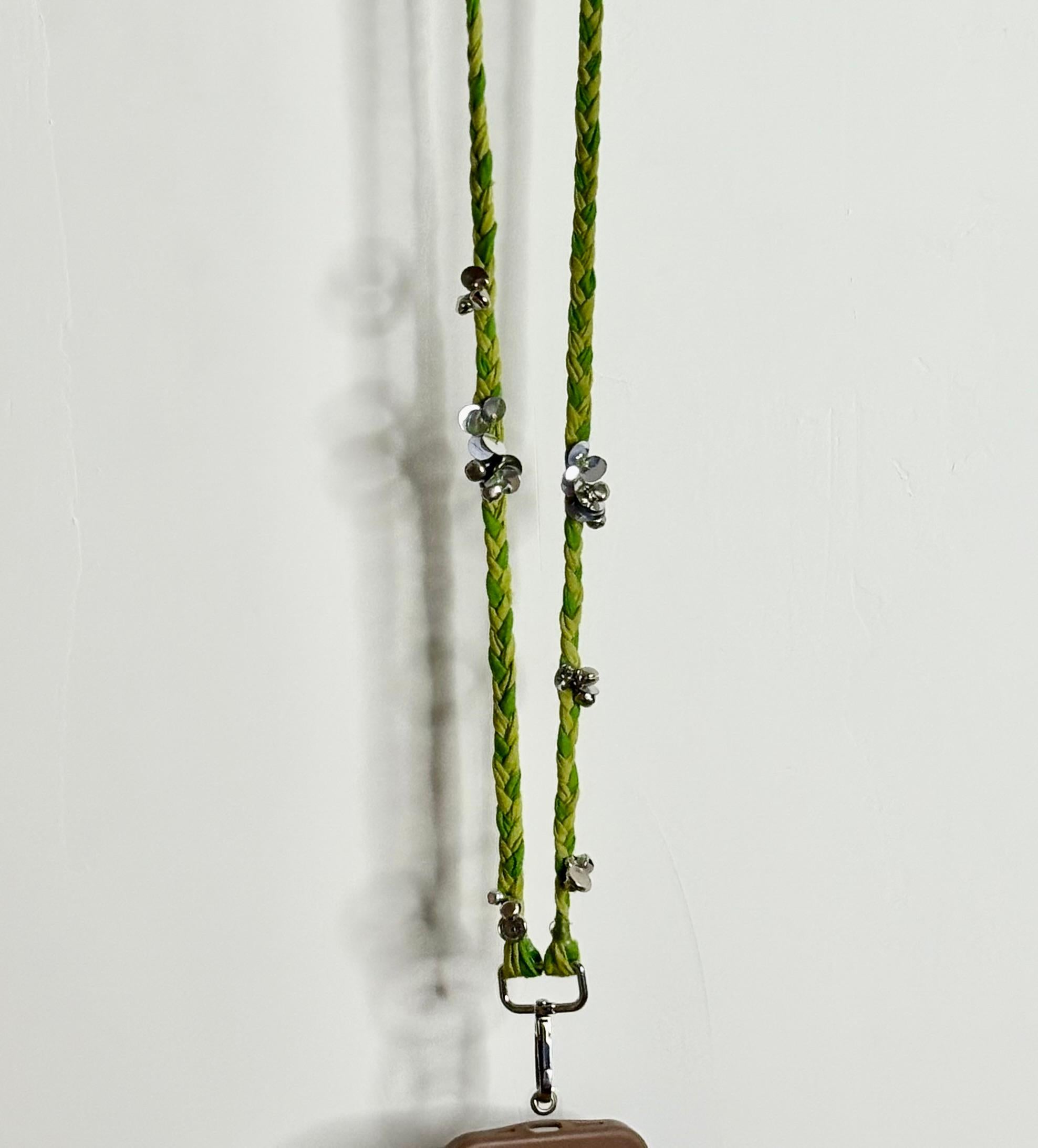 Green braided lanyard with metal clips on a white background