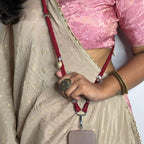 Person wearing traditionals with phone hung with fabric sling/lanyard in maroon colour