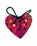 A heart-shaped embroidered pouch with a dark green loop handle, featuring a vibrant pink and green floral pattern with gold-tone metal studs, on a plain white background.