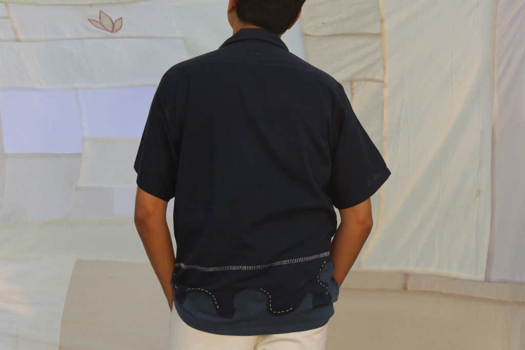 Person wearing pure cotton vacation shirt with relaxed fit and minimal design, breathable summer shirt ideal for travel and holiday outfits.
