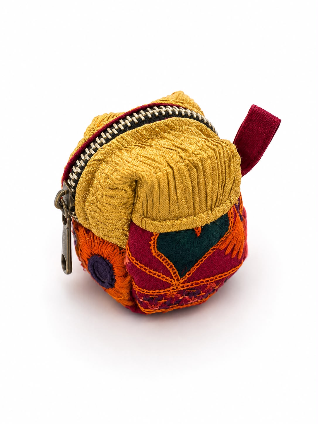A small handmade patchwork fabric coin purse with a yellow ribbed knit top, orange and red embroidered sides, a dark green heart detail, and a silver zipper pull, shown on a white background.