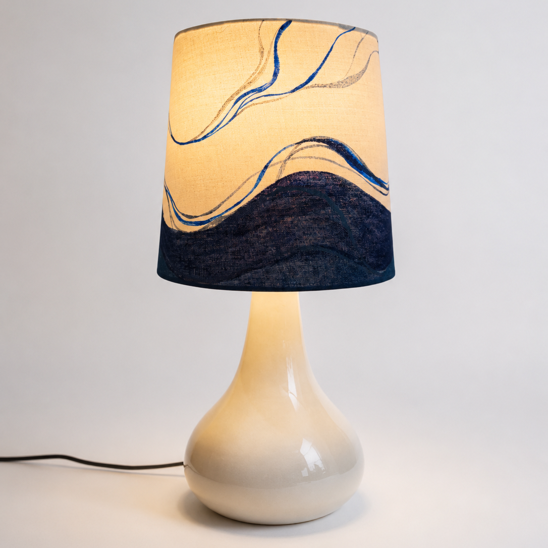 Lamp with a marbled design on the shade against a plain background