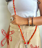 Person wearing a white top and beige pants with a red and yellow lanyard.