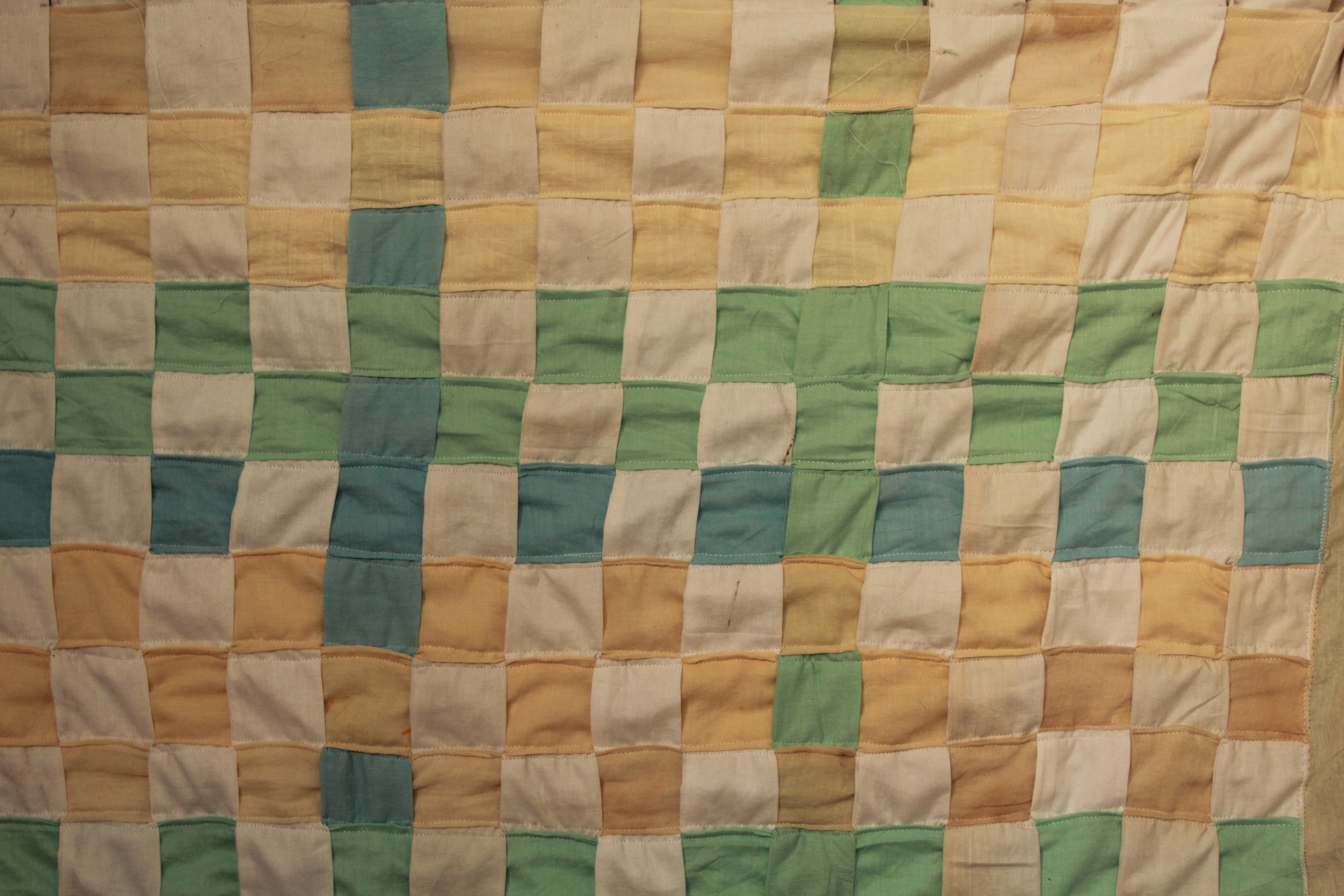 Woven curtain quilt with a grid of squares in various colors