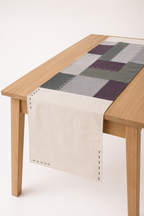 Wooden table with a patchwork table runner on a white background