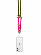 A clear phone case with a silver metal clasp, attached to a vibrant pink and olive green braided cord adorned with small gold beads, shown on a white background.