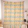 Colorful woven tapestry hanging on a wall in a room with wooden floor and furniture.