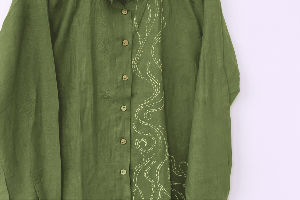 Green shirt with intricate white embroidery on a white background