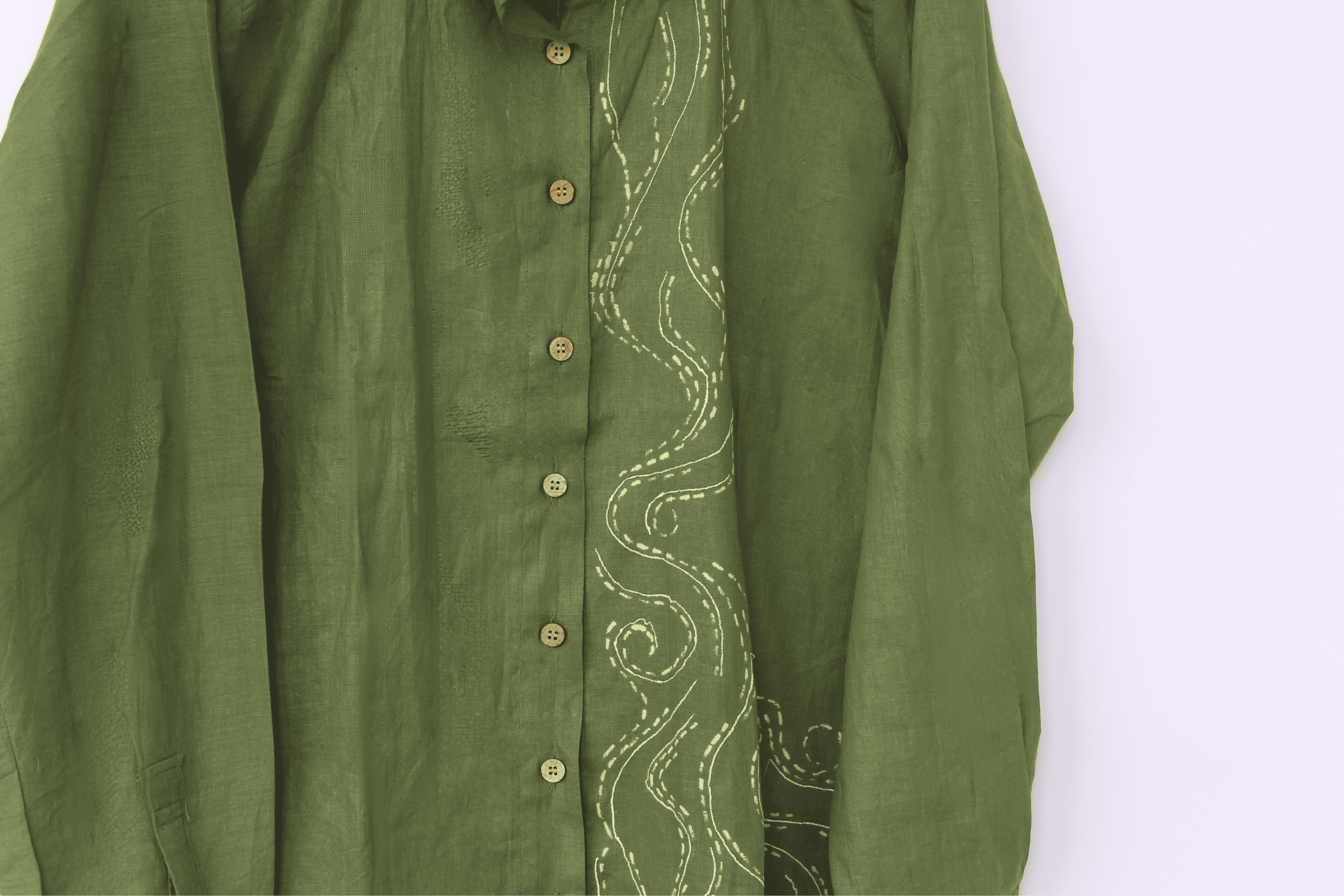 Green shirt with intricate white embroidery on a white background