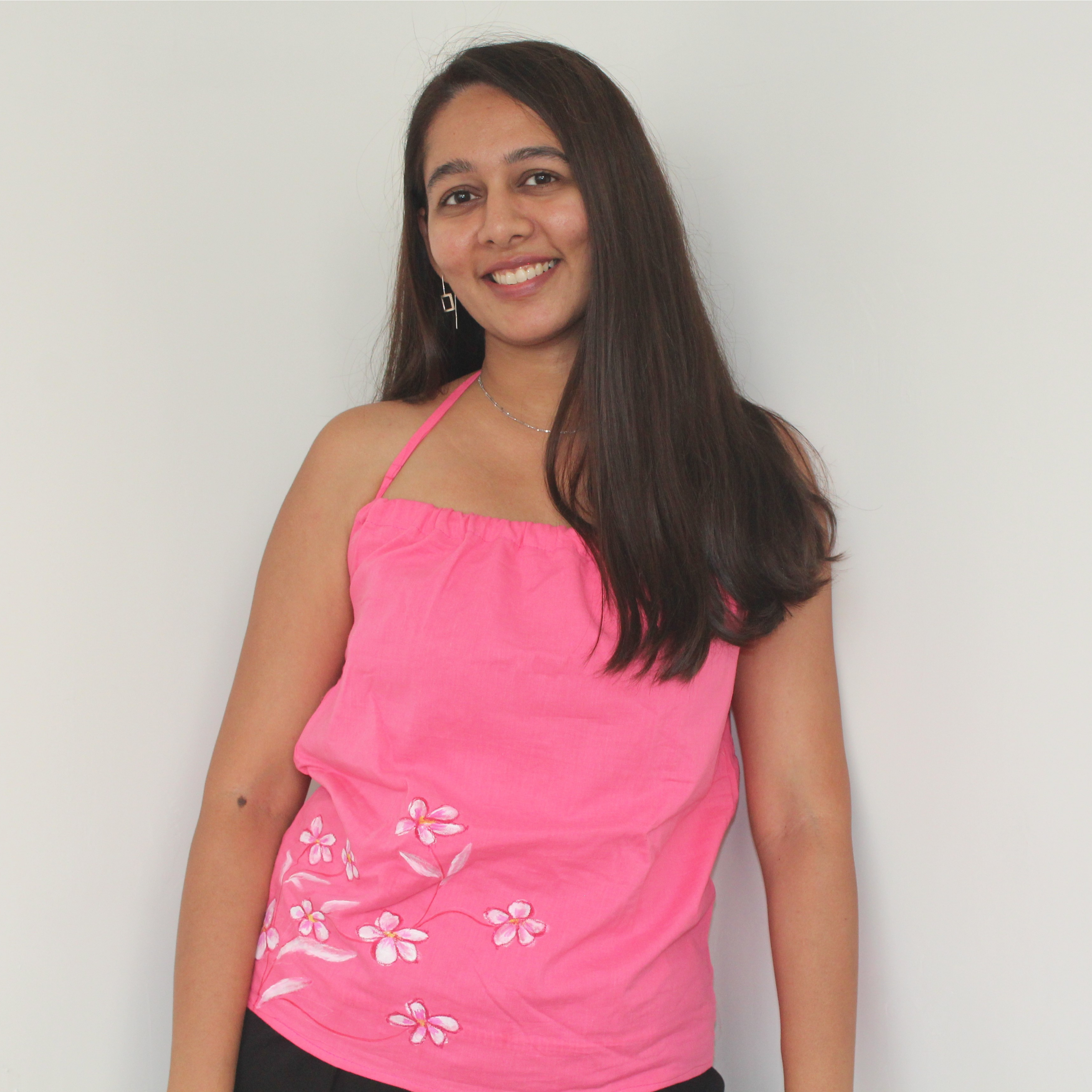 Woman wearing a pink tank top with white floral patterns hand painted