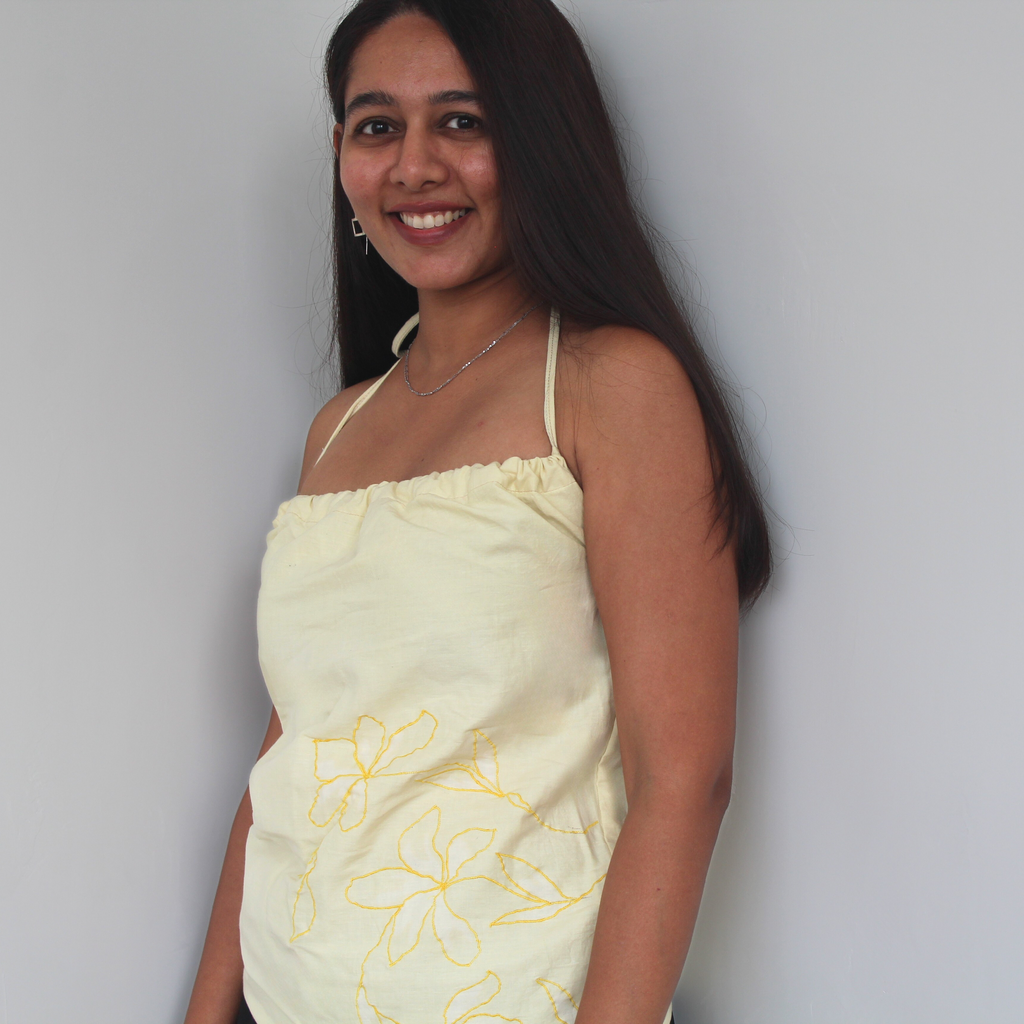 Woman wearing a lime yellow strapless dress with floral patterns 