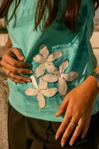 Teal cotton sleeveless top with floral design detail, breathable summer top styled for casual outings.