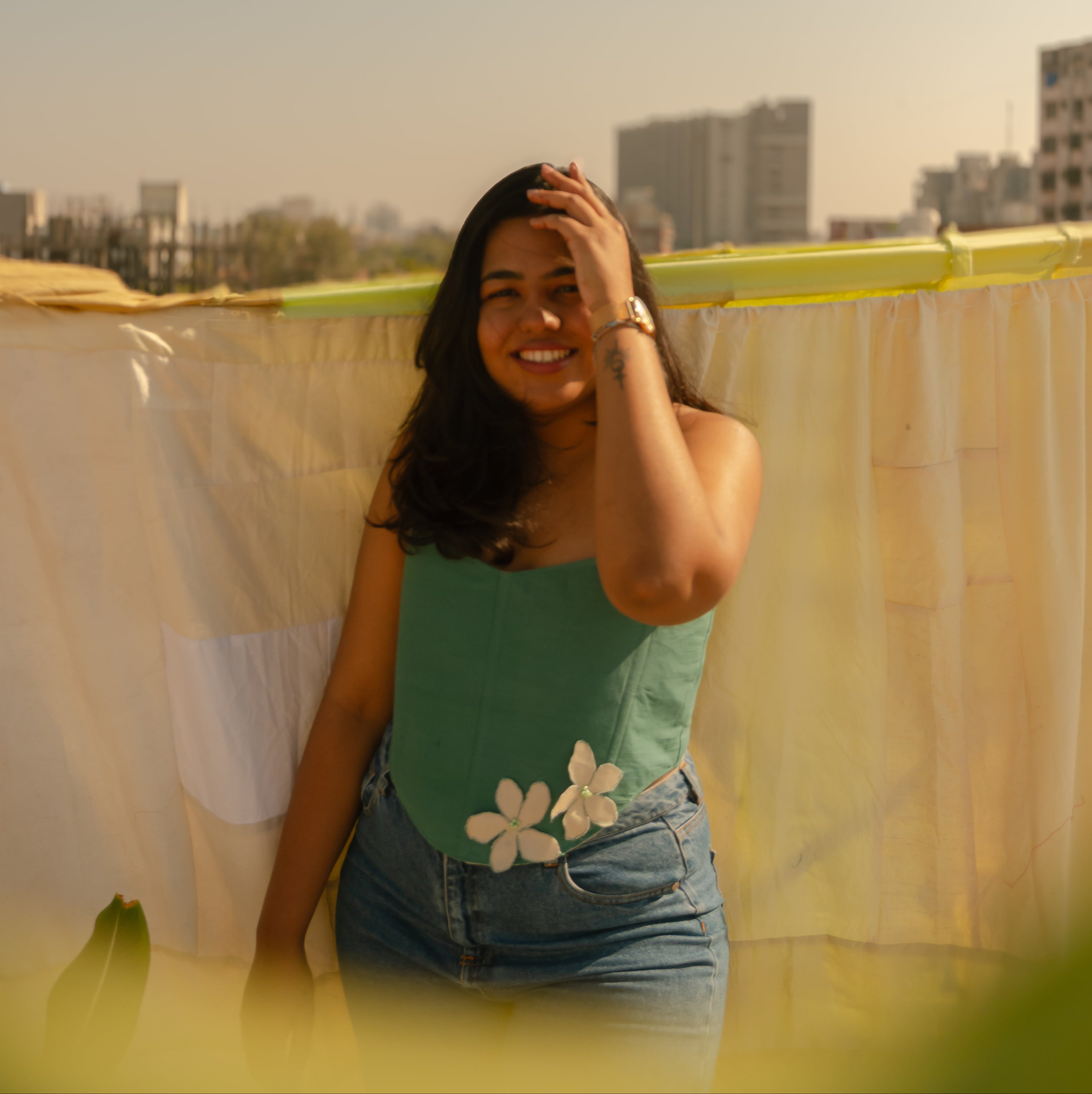 Woman wearing a Teal floral corset top with white flower detailing, strapless cotton corset top styled for summer outings and casual parties.