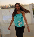Woman in a turquoise top with floral design 