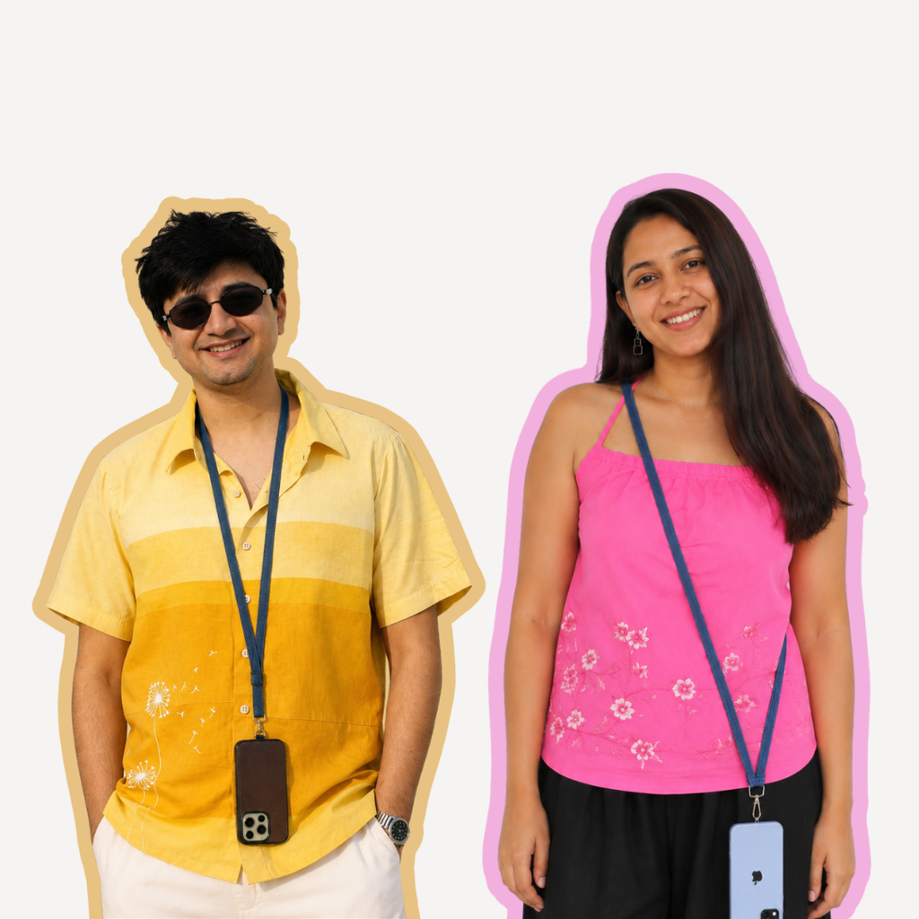 Two people standing side by side against a plain light background, each wearing a blue lanyard with a phone case. The person on the left wears a yellow striped short-sleeve shirt and white pants, while the person on the right wears a bright pink sleeveless top and black pants.