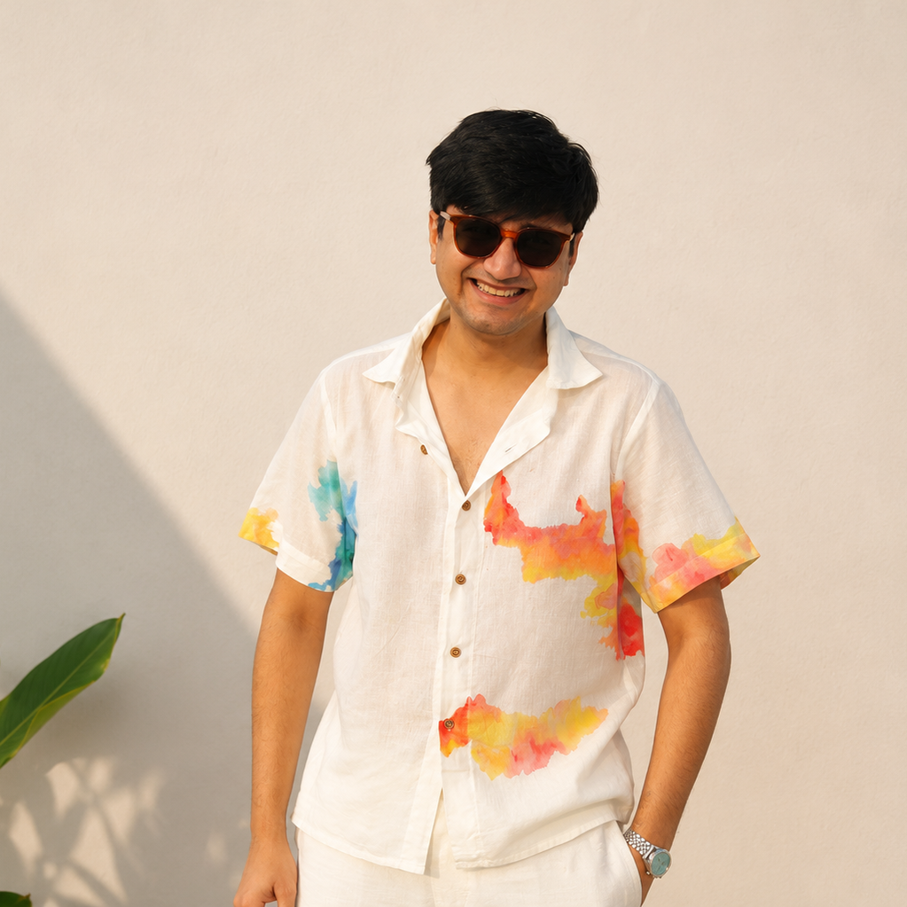 Man wearing a colorful shirt with abstract patterns against a plain background