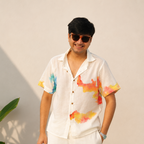 Man wearing a colorful shirt with abstract patterns against a plain background