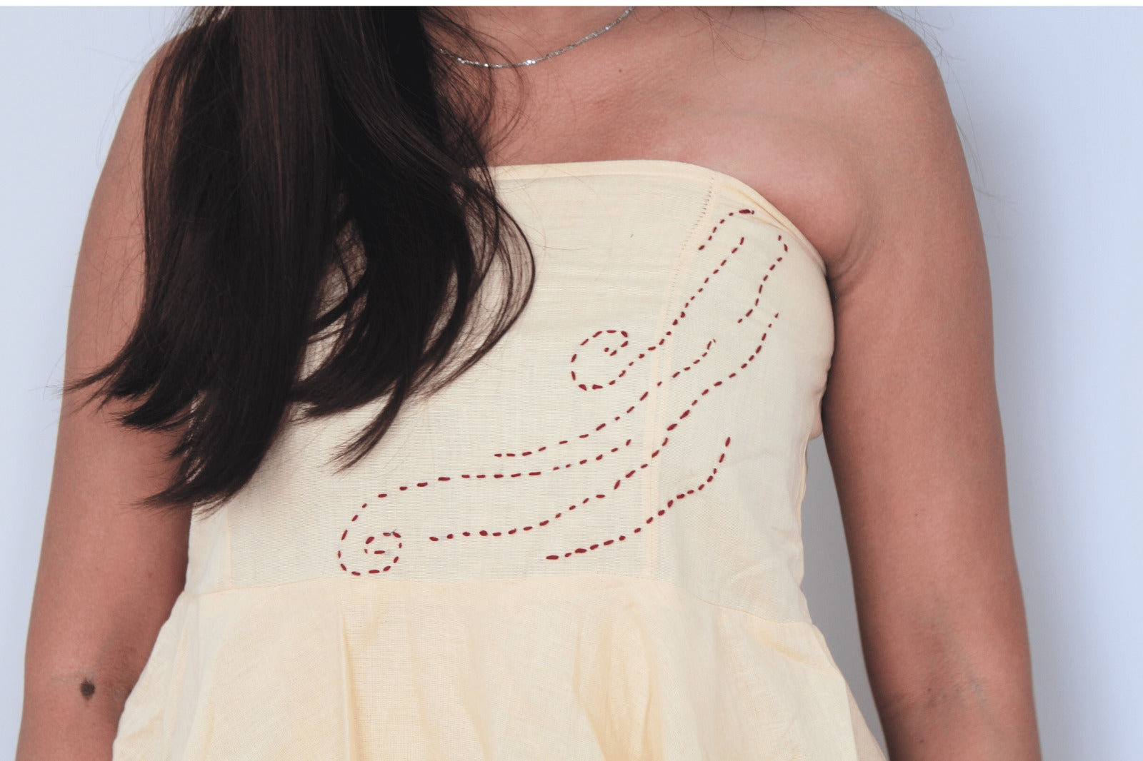 Light yellow strapless dress with red embroidery