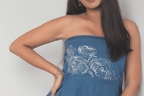 Woman wearing a blue strapless dress with white tree bark designs