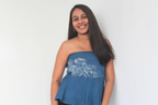 Woman wearing a blue strapless top with white design 