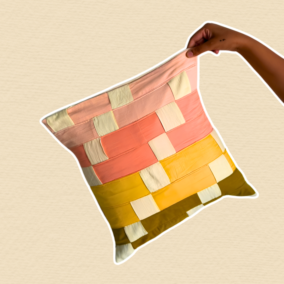 Colorful patchwork pillow held by a hand on a beige background