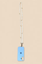 A light blue phone case with a white woven lanyard strap featuring small gold beads, shown on a solid beige background.